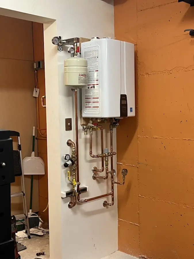 Plumbing technician inspecting water heater connections in Chesterfield